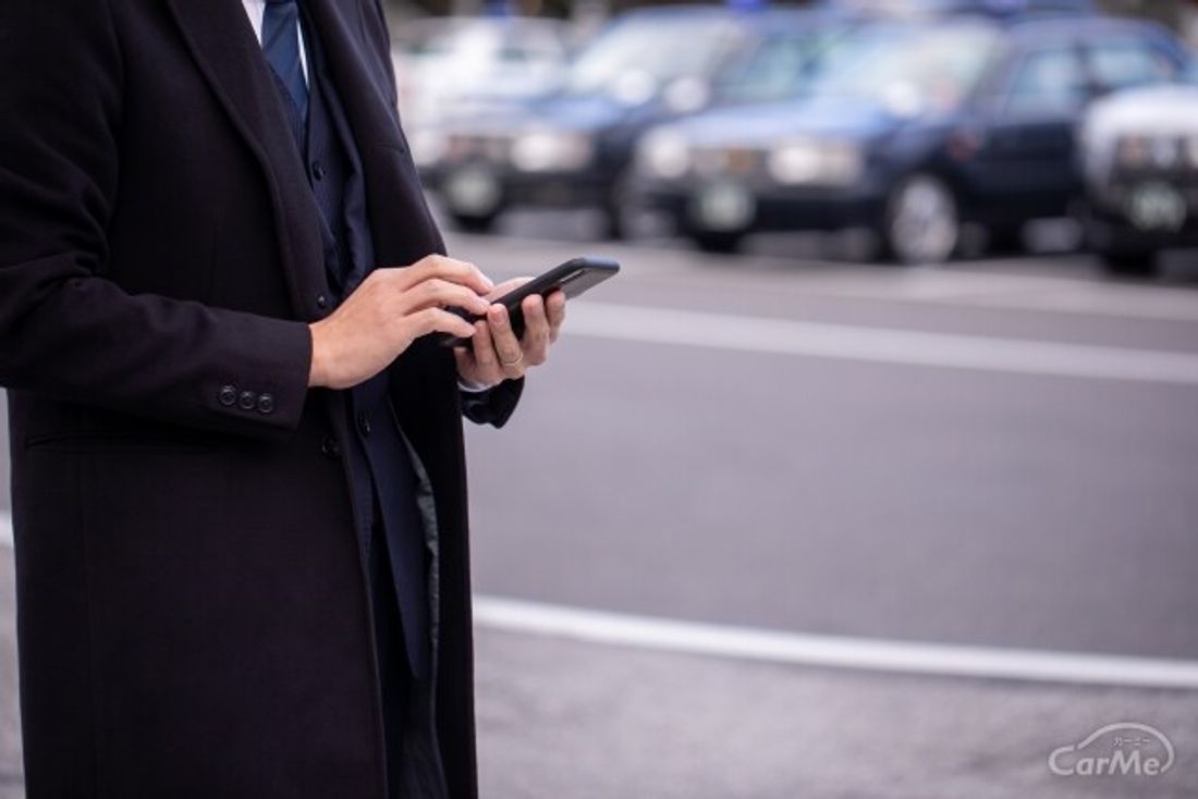 駅前でスマホを触る男性