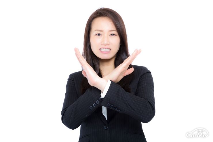 バツ印をだす女性の写真